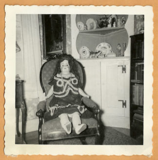 big-doll-sitting-in-chair-front